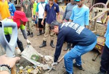 Dengan memegang sekop Walikota Vicky Lumentut membantu mengangkat sampah bercampur lumpur yang berserakan di jalan